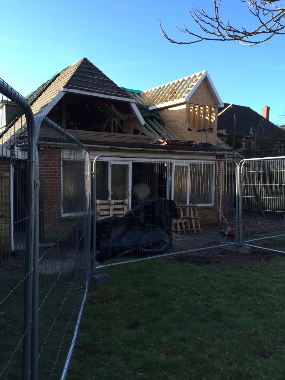 Bungalow mid-remodel with new roof framing and a gable dormer going up
