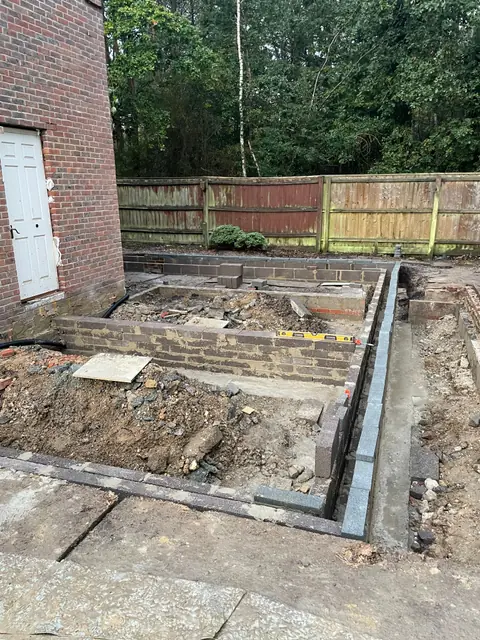 Blockwork footings built up out of the ground beside the house