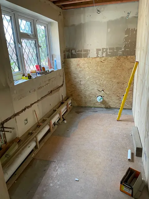 A room at first fix stage, with pipework along the wall ready for plastering