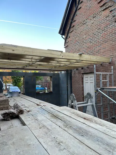 First floor joists laid over the new blockwork walls of the extension
