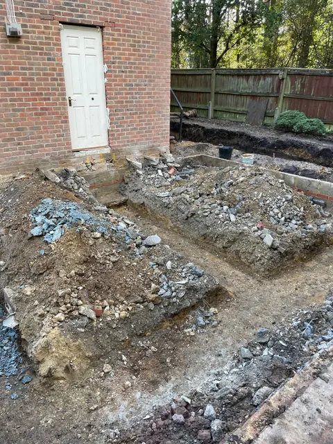 Excavated foundation trenches next to the side door of the house