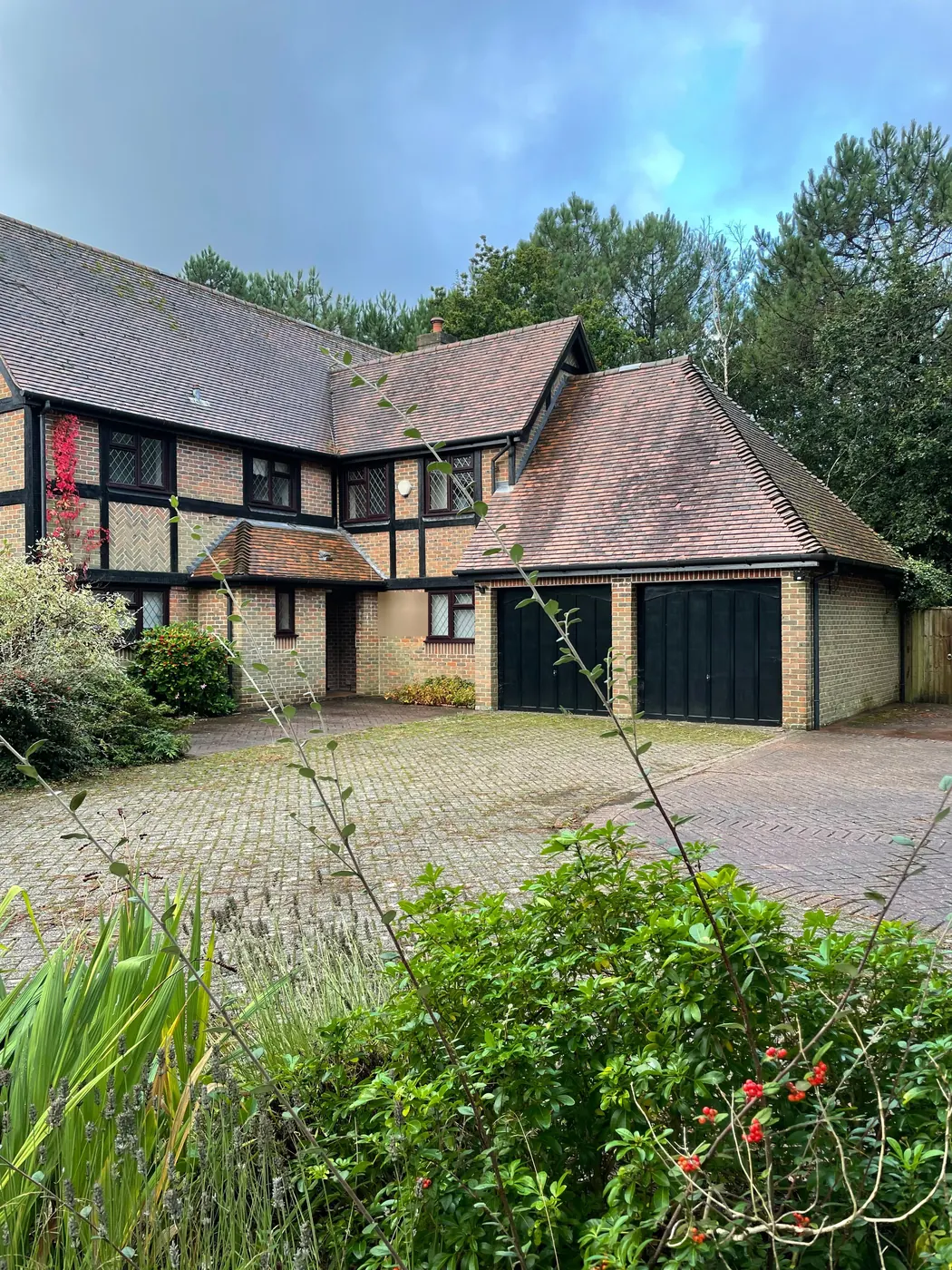 The front of the house before work started: a mock Tudor detached house with a double garage and a block paved drive