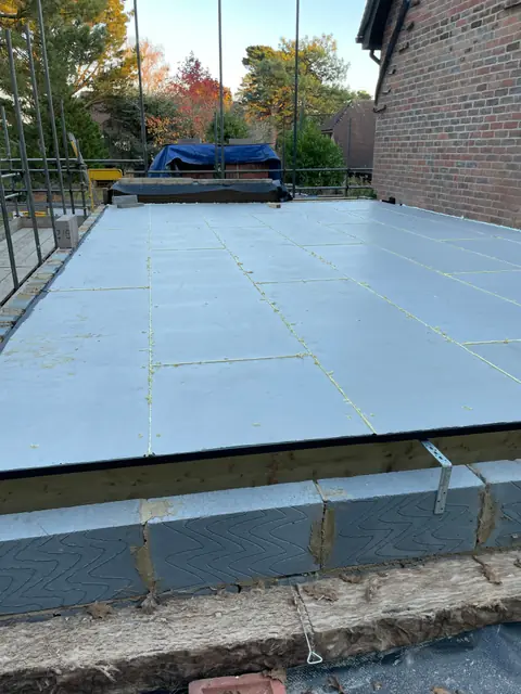Grey insulation boards laid across the new deck of the extension