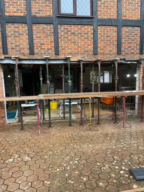 The rear of the house with the ground floor wall removed and the wall above held on props