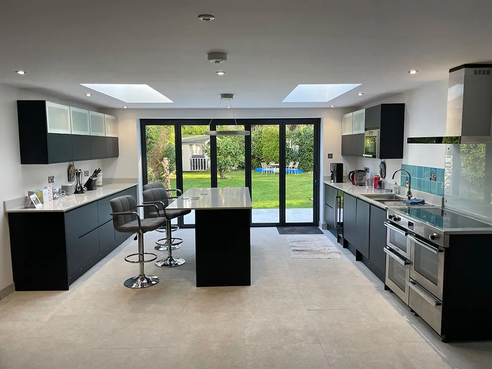 Dark fitted kitchen with island and bifold doors